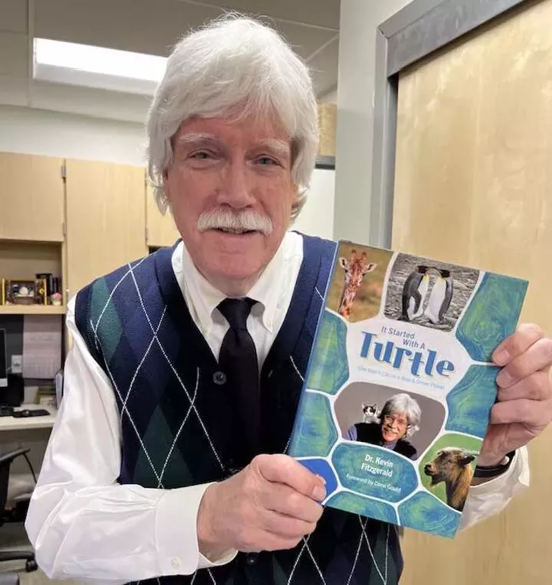 Image: Man holds a book.