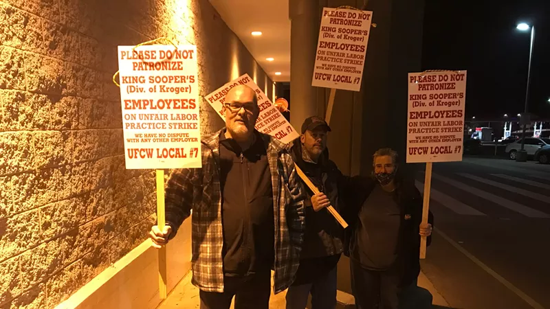 Image: Three King Soopers employees on the picket line at a southwest Jefferson County store early on January 12.