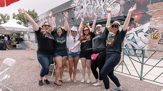 a group of women posting with their arms in the air