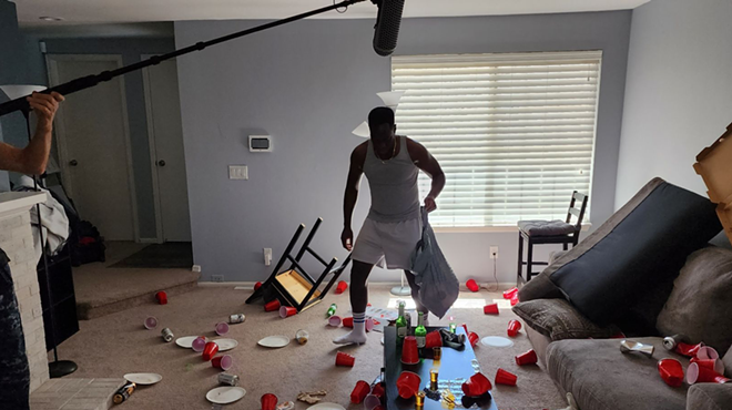 a man stands in a room with solo cups all over the floor