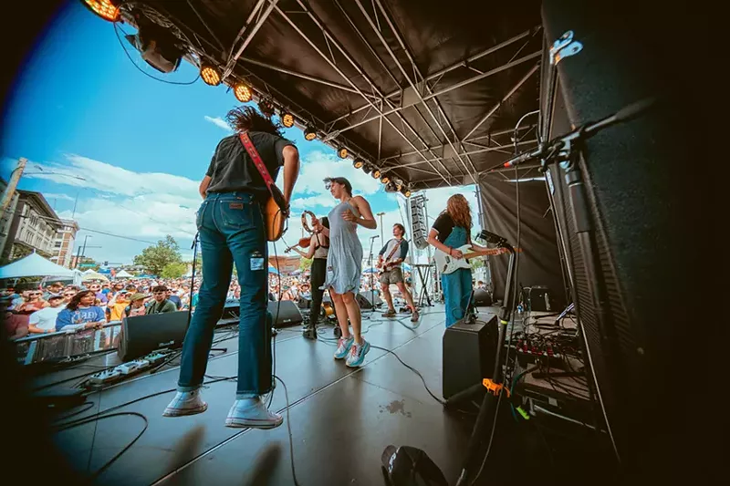 Image: band on outdoor stage.