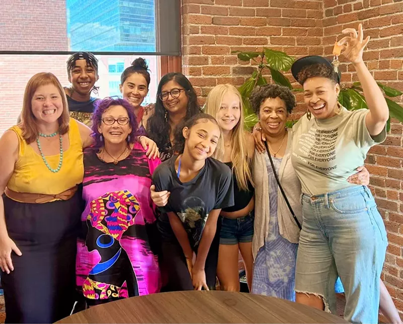 Image: A group of women smiling at the camera with arms around each other.