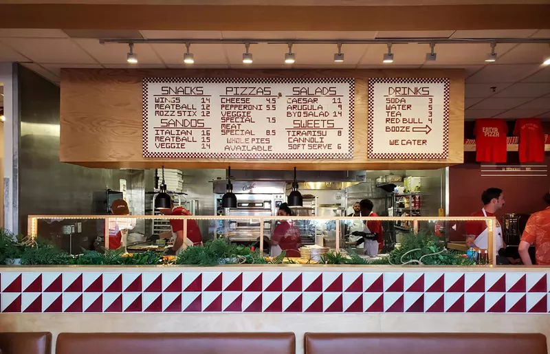 Image: view of a menu hanging over an ordering line inside a restaurant