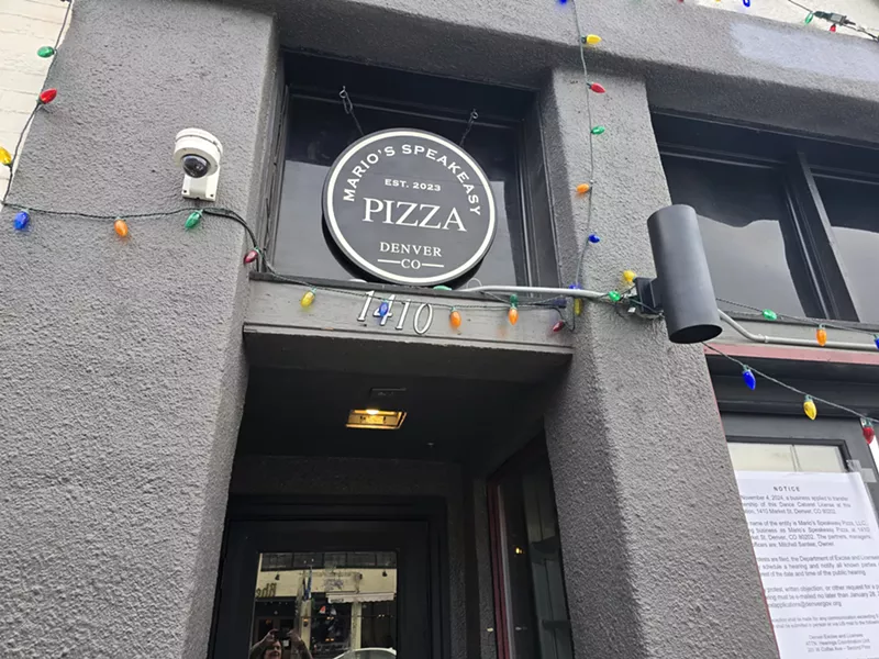 Image: "mario's speakeasy pizza" sign over a doorway