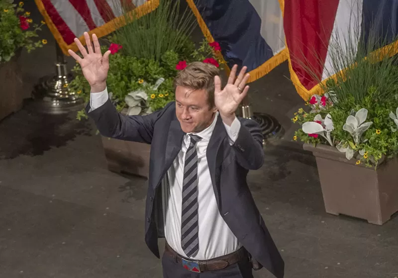 Image: new mayor in tie raises hands