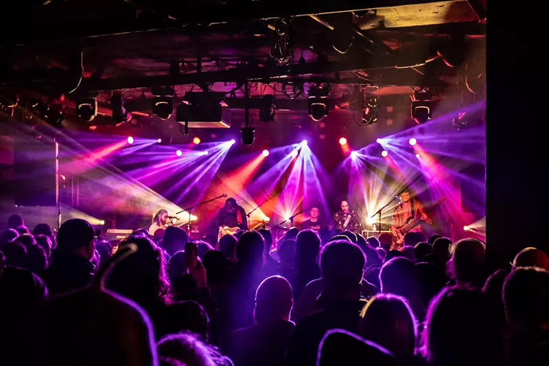 Image: jam band on stage with purple lights