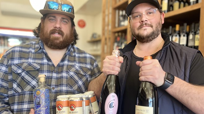 two men holding bottles of wine and cans of beer