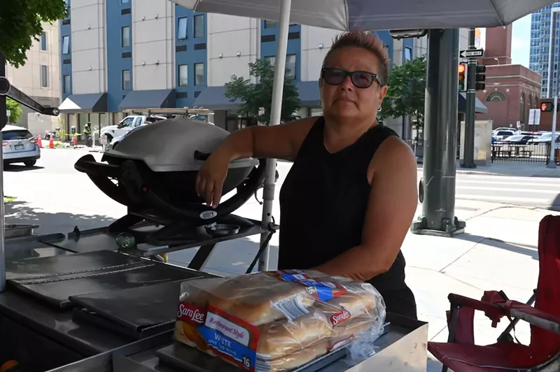 Image: Marcella Armas stands at her hot dog cart by Denver City Hall.