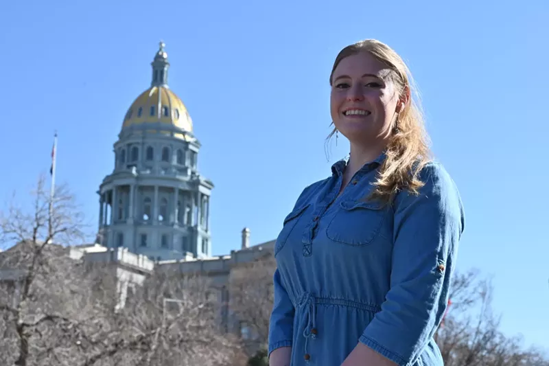 Image: A woman stands in front of the Colorado State Capitol.
