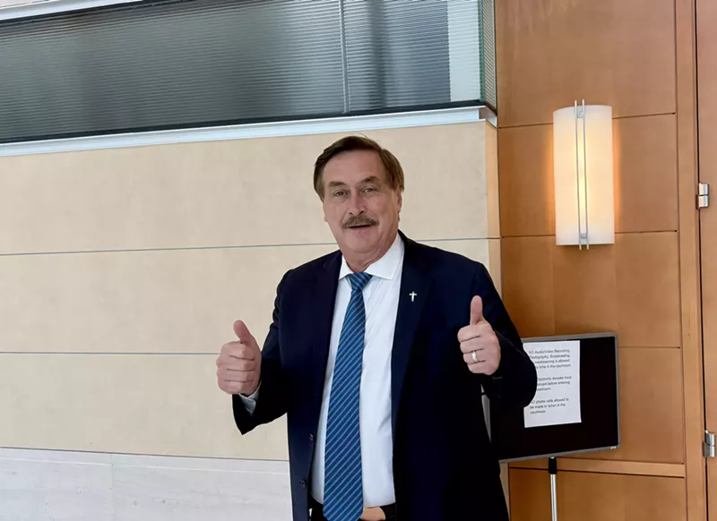Image: MyPillow CEO Mike Lindell puts two thumbs up outside the courtroom where he's being sued for defamation