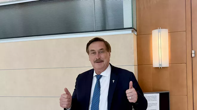 MyPillow CEO Mike Lindell puts two thumbs up outside the courtroom where he's being sued for defamation