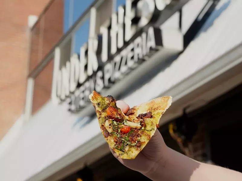 Image: hand holding slice of pizza