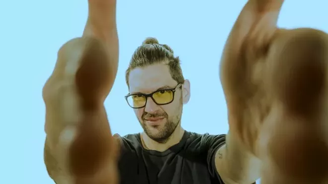 man in yellow sunglasses framing camera lens with hands