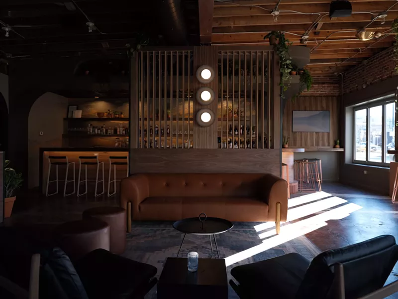 Image: interior of a bar with a brown couch in front of it