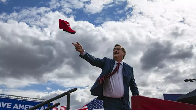 Mike Lindell of MyPillow tosses a MAGA hat into the air