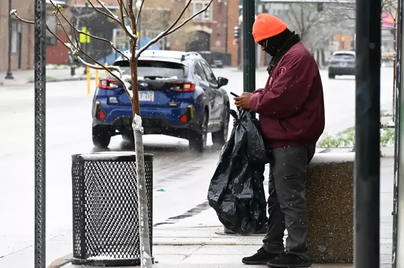 Image: A man replaces a trash bin.