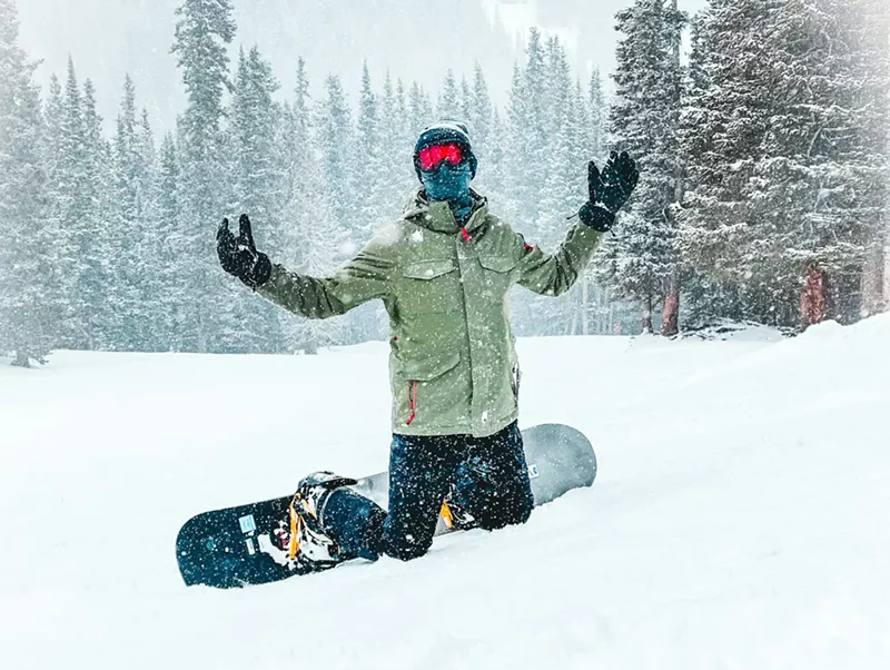 Image: Man snowboards on Colorado mountain in snow
