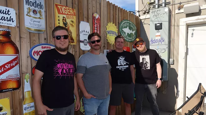 four men standing in front of a bar