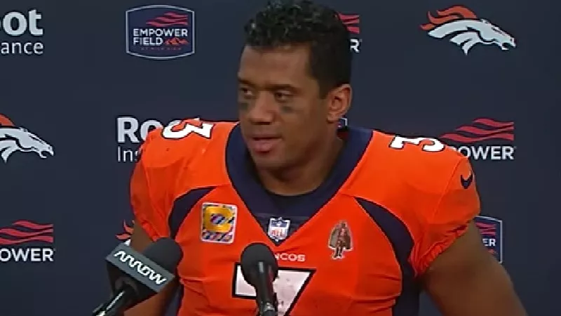 Image: Russell Wilson remained in uniform while addressing the media after the Broncos' 12-9 overtime loss to the Indianapolis Colts.