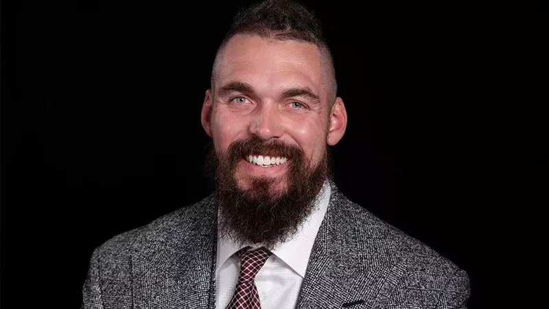 Image: A formal portrait of Derek Wolfe.