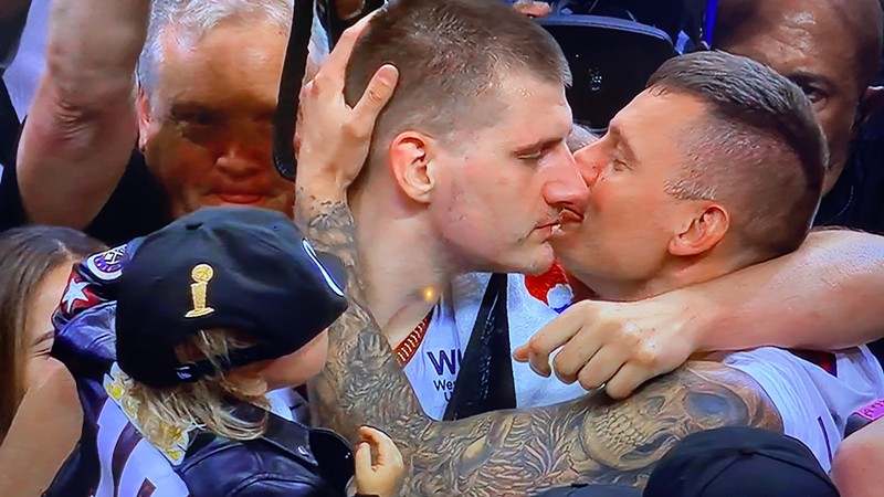Nikola Jokic enjoying a post-game smooch (from one of his brothers) after the Denver Nuggets won the NBA championship on June 12.