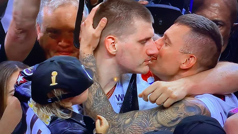 Image: Nikola Jokic enjoying a post-game smooch (from one of his brothers) after the Denver Nuggets won the NBA championship on June 12.
