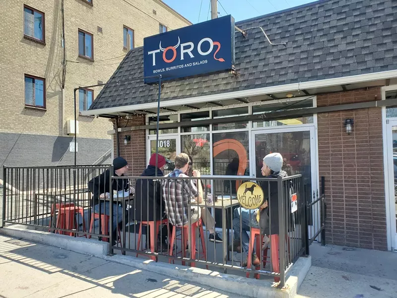 Image: people eating outside on restaurant patio.
