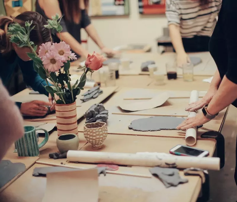Image: people roll out clay in a craftroom