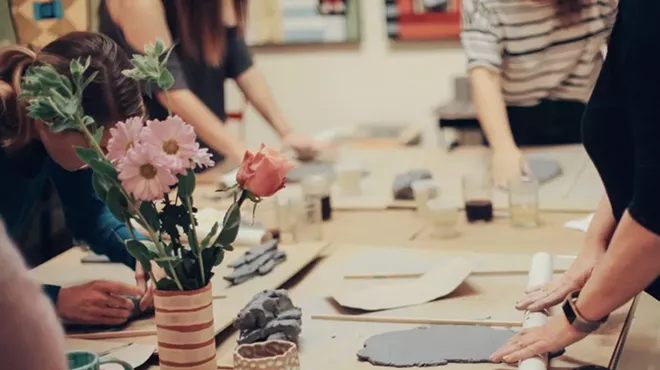 people roll out clay in a craftroom