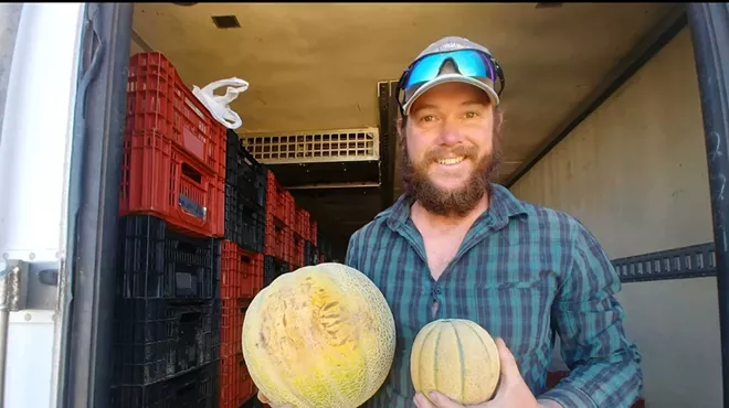 a man holding two melons