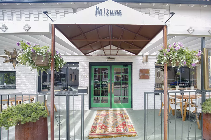Image: front entry of a restaurant with an awning over a patio