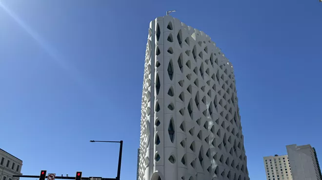 tall building with weird windows against blue sky.