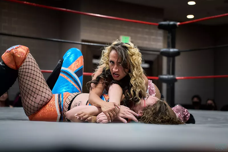Image: A female wrestler pins down another wrestler