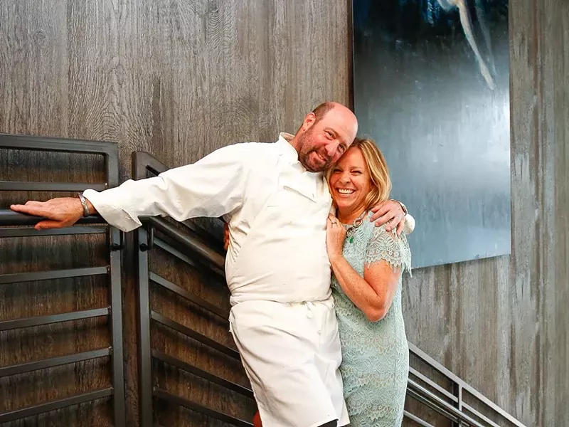 Image: man in chef outfit hugging wife