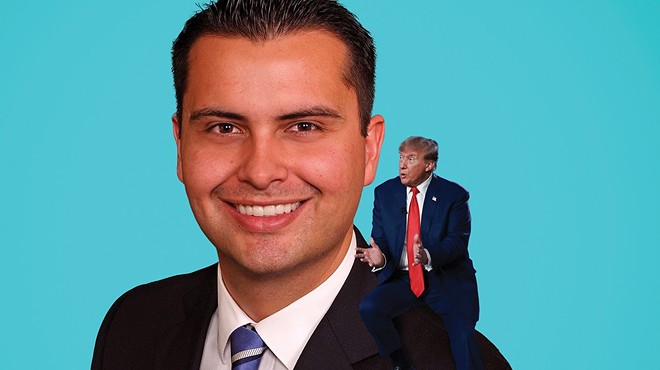 man in suit with Trump on his shoulder.