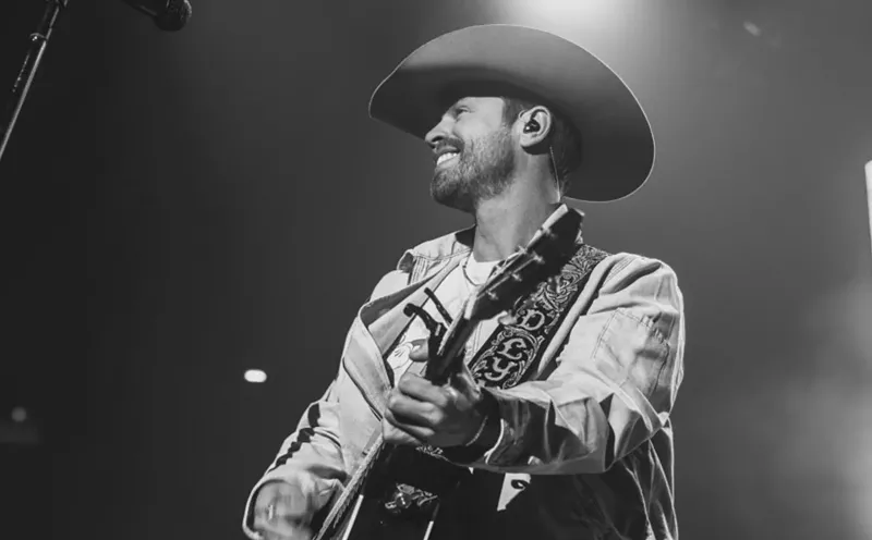 Image: man in cowboy hat playing guitar