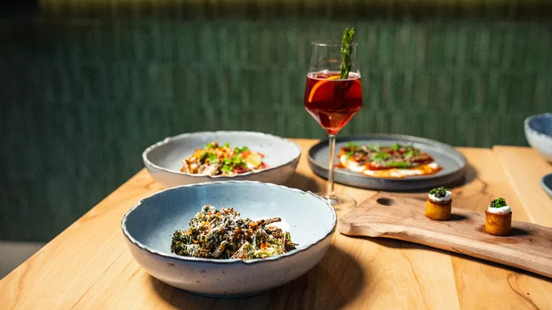 Image: glass of wine and various dishes on a table