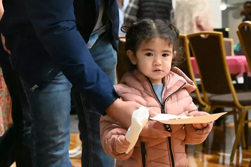 Image: A little girl holds a plate.
