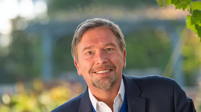 man with beard in blue jacket, white shirt
