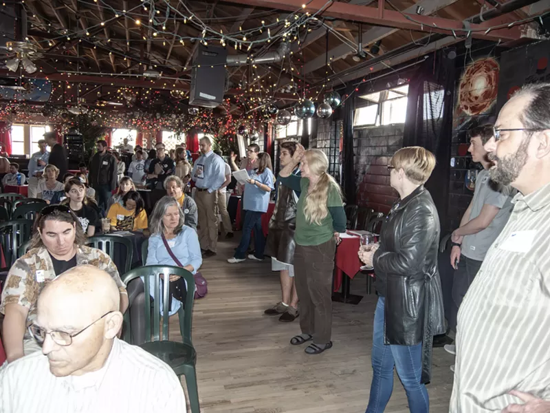 Image: woman talking to gathering in cafe