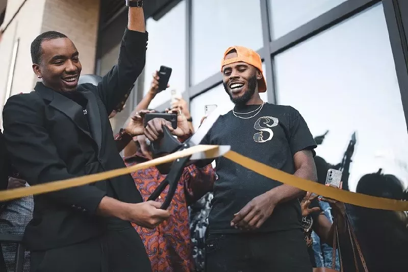 Image: Co-owners Khristian Matthews (left) and Ki’erre Dawkins cutting the gold ribbon at the grand opening of Saucy's Southern.