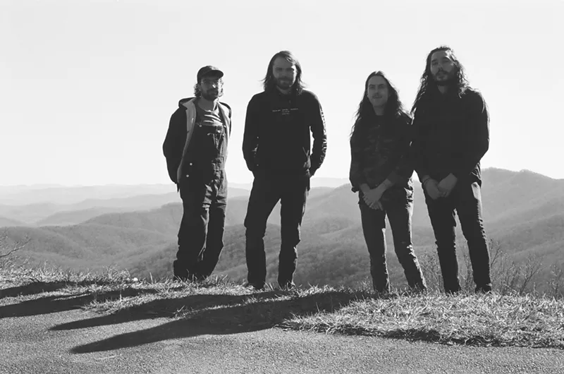 Image: four men with mountains in the background