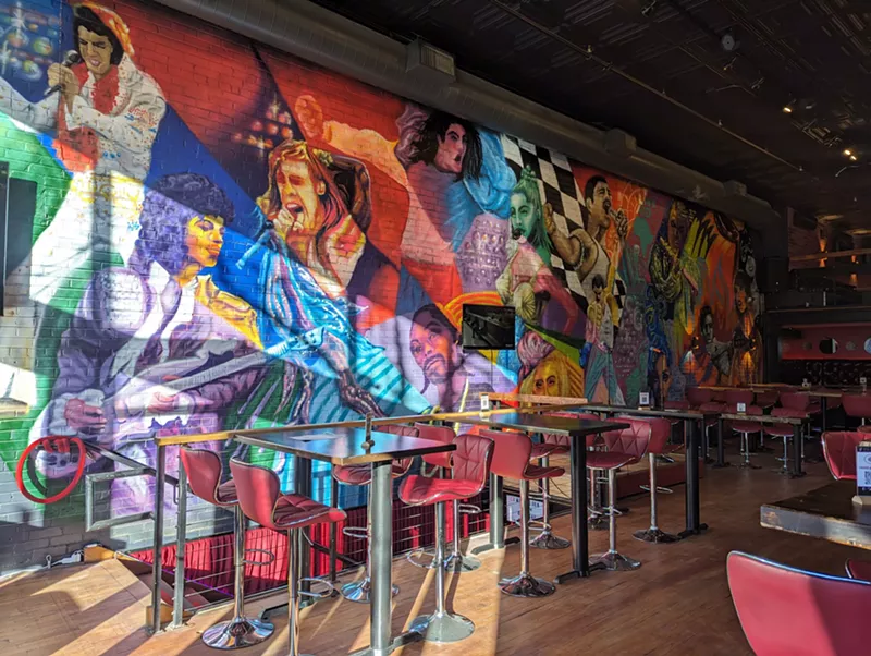 Image: a colorful mural on a wall picturing famous singers