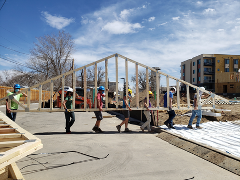 Image: workers carrying part of houses