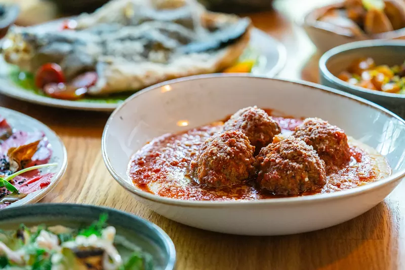 Image: a plate of meatballs over polenta