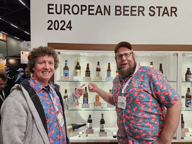 Image: Two brewers sharing competition medals.