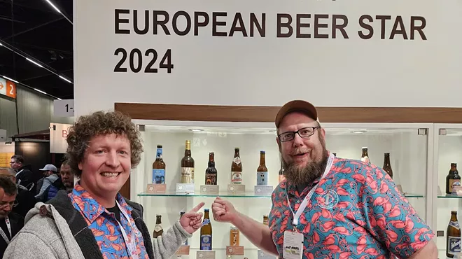 Two brewers sharing competition medals.