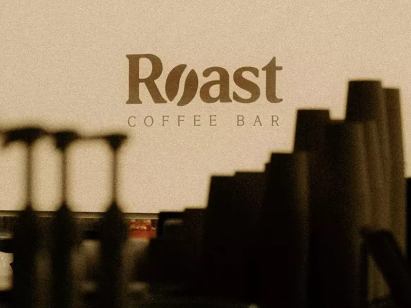 Image: "roast coffee bar" logo behind pump bottles