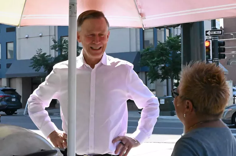 Image: John Hickenlooper talks with Marcella Armas at her hot dog cart on 14th Avenue and Cherokee Street.