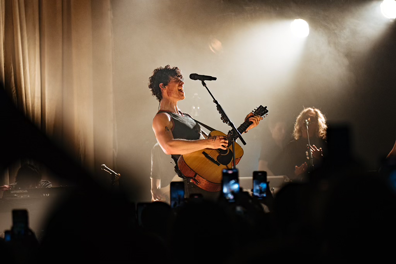 Image: shawn mendes performing on stage with a guitar